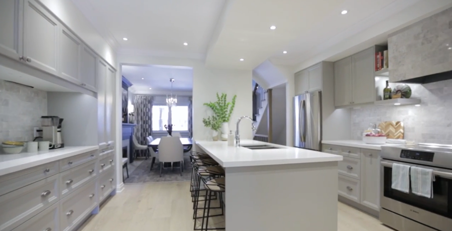 Bright remodeled kitchen with white island, light cabinetry, recessed lighting, and stainless steel appliances.